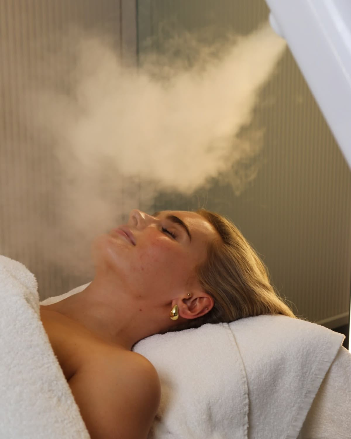 Woman receiving a steam treatment in a spa setting